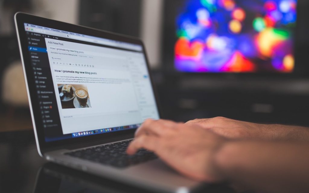 Osoba postavlja tekst na WordPress sajt na laptopu