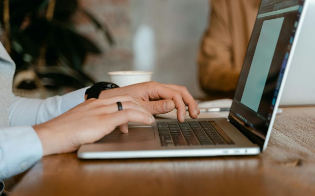 Osoba drži ruke na tastaturi laptopa