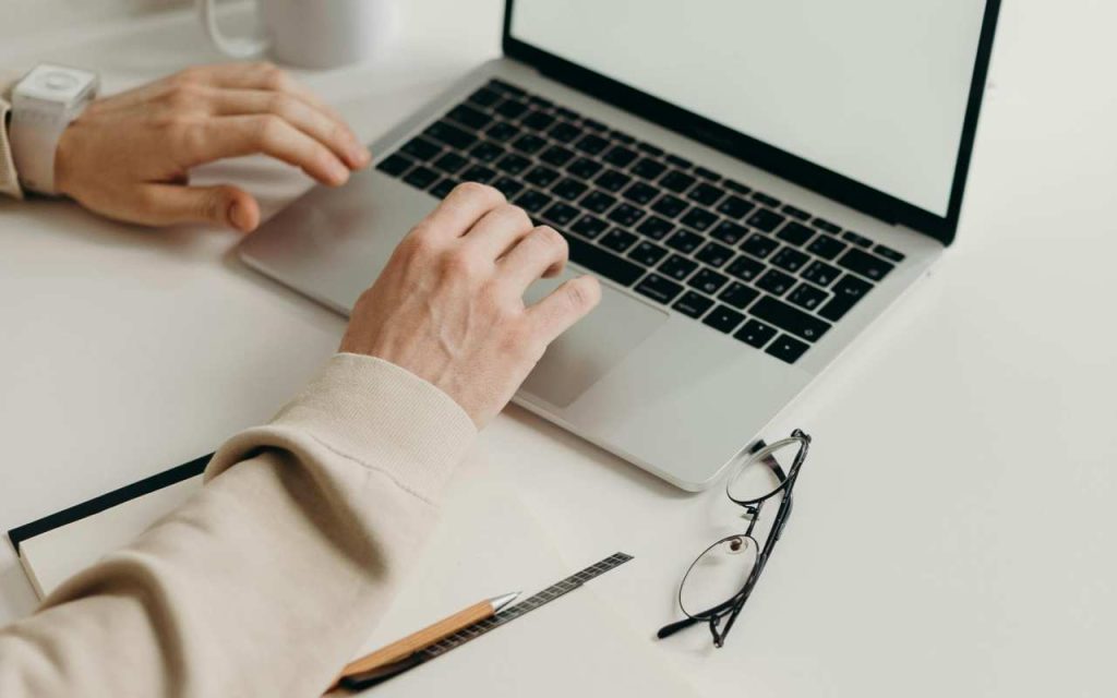 Osoba kuca na laptopu.